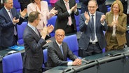 Alexander Dobrindt (CSU, 2. von rechts) und Jens Spahn (CDU, links) applaudieren dem neu gewählten Bundeskanzler Friedrich Merz (CDU, Mitte) bei der Kanzlerwahl im Bundestag. © dpa Foto: Michael Kappeler