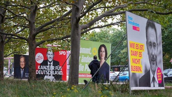 Wahlplakate der Union mit Armin Laschet, der SPD mit Olaf Scholz, von Bündnis 90/Die Grünen mit Annalena Baerbock und der FDP mit Christian Lindner stehen einen Tag nach der Bundestagswahl in einer Reihe.  