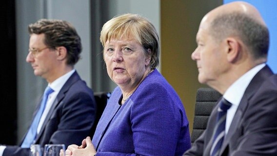 NRW-Ministerpräsident Hendrik Wüst (CDU), Bundeskanzlerin Angela Merkel (CDU), geschäftsführender Bundesfinanzminister Olaf Scholz (SPD)(v.l.n.r.) © picture alliance / ASSOCIATED PRESS Foto: Michael Kappeler