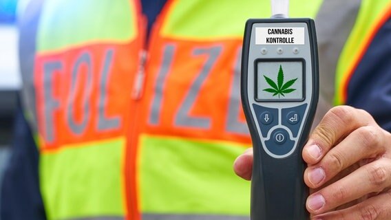 Ein Polizist hält ein Cannabis-Testgerät in der Hand. © picture alliance / CHROMORANGE Foto: Michael Bihlmayer
