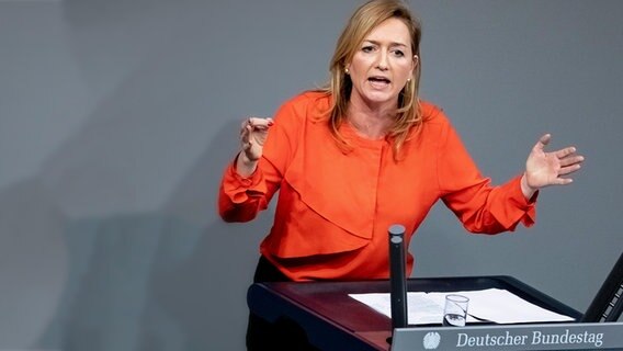 Die Politikerin Caren Lay steht am Rednerpult im Bundestag vor einer grauen Fläche. Mit den Armen gestikuliert sie während ihrer Rede. Die Politikerin Caren Lay steht am Rednerpult im Bundestag vor einer grauen Fläche. Mit den Armen gestikuliert sie während ihrer Rede. © dpa picture alliance Foto: Christoph Soeder