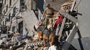 Ein ukrainischer Soldat sucht in Charkiw mit einem Hund nach Opfern in einem Wohnhaus, das nach einem russischen Bombenangriff schwer beschädigt wurde. © AP/dpa Foto: Andrii Marienko