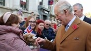 König Charles III. wird von Bürgern und einem kleinen Hund begrüßt, als er zu einer Zeremonie im Mansion House eintrifft, um Doncaster den Status einer Stadt zu verleihen. © Molly Darlington/PA Wire/dpa 