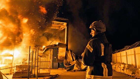 Feuerwehrleute des staatlichen ukrainischen Katastrophenschutzes löschen ein Feuer in der Stadt Cherson, nachdem russischer Granatenbeschuss ein Einkaufszentrum getroffen hat. © Libkos/AP/dpa 