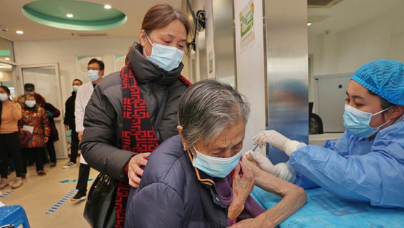 Eine Krankenschwester verabreicht einer alten Frau in einem kommunalen Gesundheitszentrum in Nantong in der ostchinesischen Provinz Jiangsu eine Corona-Impfung. © Uncredited/CHINATOPIX via AP/dpa 