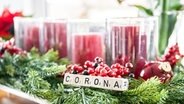 Auf einem Adventskranz steht das Wort Corona. © picture alliance / Fotostand Foto: K. Schmitt