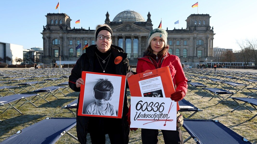 Ricarda Piepenhagen (l.) und Elena Lierck demonstrieren am 19. Januar 2023 stellvertretend für LongCovid- und ME/CFS-Betroffene vor dem Reichstagsgebäude in Berlin.