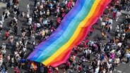 Viele Menschen und riesige Regenbogen-Fahne © Fabian Sommer/dpa 