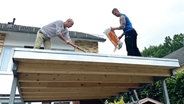 Martin Granseuer und Geselle Richard Ockert beim Anlegen einer Dachbegrünung © NDR Foto: Wiebke Neelsen