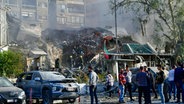 Auf diesem von der staatlichen syrischen Nachrichtenagentur SANA zur Verfügung gestellten Foto versammeln sich Menschen in der Nähe eines zerstörten Gebäudes. Bei einem mutmaßlich israelischen Luftangriff in der syrischen Hauptstadt Damaskus ist nach Angaben aus Teheran ein General der iranischen Revolutionsgarden getötet worden. © Uncredited/SANA/AP/dpa 