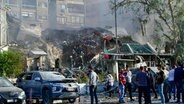 Auf diesem von der staatlichen syrischen Nachrichtenagentur SANA zur Verfügung gestellten Foto versammeln sich Menschen in der Nähe eines zerstörten Gebäudes. Bei einem mutmaßlich israelischen Luftangriff in der syrischen Hauptstadt Damaskus ist nach Angaben aus Teheran ein General der iranischen Revolutionsgarden getötet worden. © Uncredited/SANA/AP/dpa 