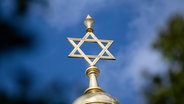 Der Davidstern auf der Kuppel des Centrum Judaicum, in dem sich auch die Neue Synagoge Berlin und die Jüdische Gemeinde zu Berlin befindet, leuchtet vor blauem Himmel. © picture alliance Foto: Sebastian Gollnow