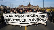 Hinter einem Plakat mit der Aufschrift "Gemeinsam gegen den Rechtsruck in Europa" stehen Demonstranten. © dpa bildfunk Foto: Oliver Killig