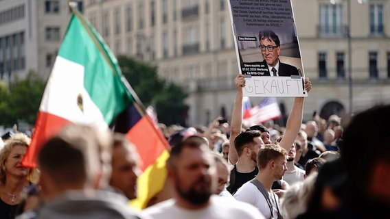 Ein Demo-Teilnehmer in Berlin hält ein Plakat von Bill Gates und dem Schriftzug "Gekauft!" vor einer Demonstration gegen die Corona-Maßnahmen. © dpa bildfunk Foto: Kay Nietfeld
