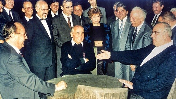 Bundeskanzler Kohl (r.), der sowjetische Staatspräsident Gorbatschow (M.) und Bundesaußenminister Genscher (l.) am 15.07.1990 im Kaukasus bei einem Gespräch zur Deutschen Einheit. © dpa/picture-alliance 