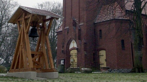 Vor der Kirche in Ahlbeck steht am 19.01.2001 ein Glockenstuhl zum Gedenken an Norbert Plath, der dort im Jahr 2000 von Neonazis erschlagen wurde. © picture-alliance / ZB Foto:  Stefan Sauer