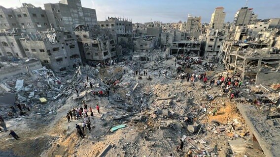 Im Flüchtlingslager Dschabalia im nördlichen Gazastreifen inspizieren Palästinenser die Schäden an Gebäuden, die von israelischen Luftangriffen getroffen wurden. © Fadi Wael Alwhidi/dpa 