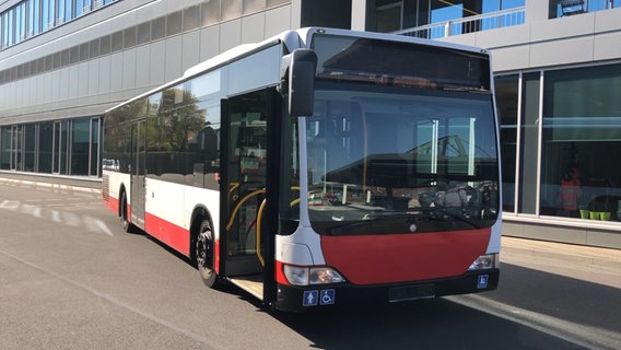 Ein HVV-Bus, der zu einem Duschbus für Obdachlose umgebaut werden soll, steht vor einem Gebäude. © NDR 