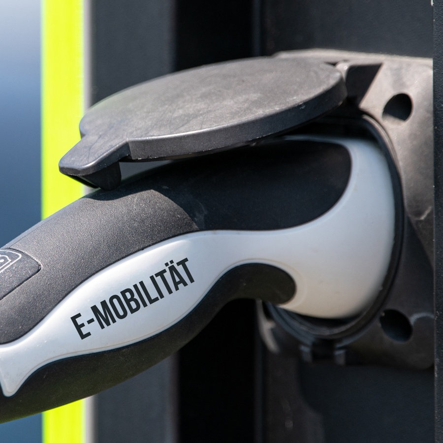 Ein symbolischer E-Auto-Ladestecker mit der Aufschrift "E-Mobilität" steckt in einer Ladesäule. © picture alliance / SULUPRESS.DE Foto: Torsten Sukrow