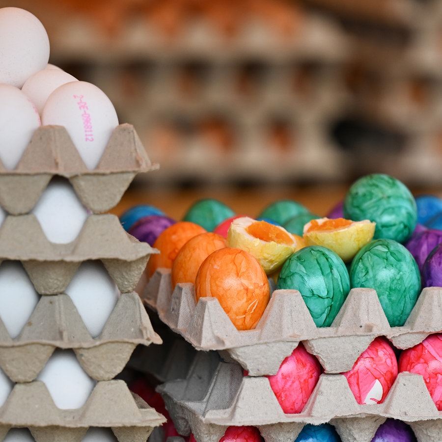 Verschiedene Eierpappen gefüllt mit bunt gefärbten und naturbelassenen Eiern übereinander gestapelt. © picture alliance/dpa Foto: Arne Dedert