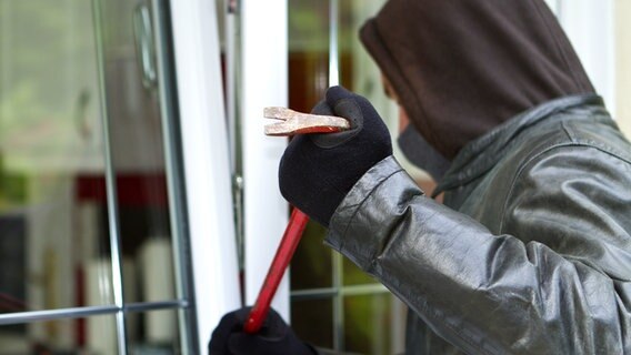 Maskierter Einbrecher bricht ein Fenster auf. © Fotolia.com Foto: sdecoret