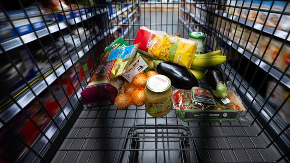 Verschiedene Lebensmittel liegen in einem Supermarkt in einem Einkaufswagen. © dpa Foto: Sven Hoppe