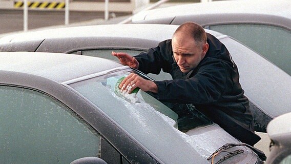 Mann kratzt Eis von der Windschutzscheibe eines Autos © dpa Foto: Kay Nietfeld