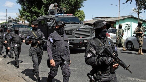 Polizeikräfte treffen in Soyapango in El Salvador ein und gehen über eine Straße. © dpa picture alliance/AP Foto: Salvador Melendez