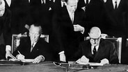 Der französische Staatspräsident Charles de Gaulle (r) und der deutsche Bundeskanzler Konrad Adenauer unterzeichnen am 22.1.1963 im Pariser Elysee-Palast den deutsch-französischen Freundschaftsvertrag. © dpa picture alliance 