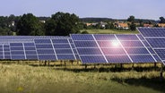 Solarpark mit Photovoltaikanlagen auf einer Wiese in ländlicher Umgebung. Die Solarmodule sind in Reihen angeordnet und nutzen Sonnenenergie zur Stromerzeugung. © Fotolia.com Foto: Michael Eichhammer