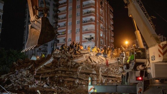 Rettungskräfte suchen in der türkischen Stadt Adana nach Überlebenden in den Trümmern von Gebäuden. © Tolga Ildun/ZUMA Press Wire/dpa 