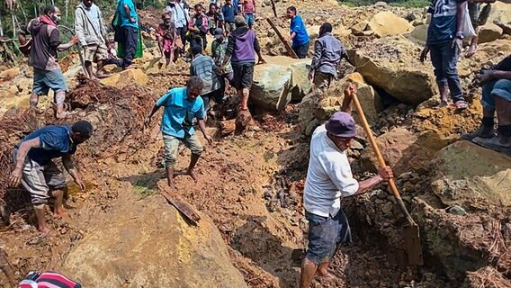 Dorfbewohner suchen nach einem Erdrutsch in Yambali in Papua-Neuguinea nach Verschütteten. © dpa bildfunk/AP/International Organization for Migration Foto: Mohamud Omer