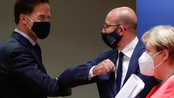 Der niederländische Premier Mark Rutte begrüßt EU-Ratspräsident Charles Michel mit den Ellenbogen, daneben steht Bundeskanzlerin Angela Merkel. © EPA Pool/AP/dpa Foto: Stephanie Lecocq