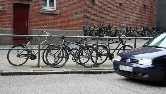 An einer Straßenbegrenzung angeschlossene Fahrräder. © NDR Foto: Florian Wöhrle