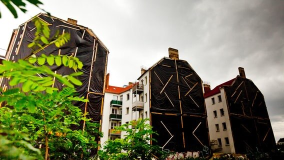 Mehrfamilienhäuser (Altbau) mit Planenabdeckung zur Fassadendämmung. © picture alliance Foto: Lutz Wallrath