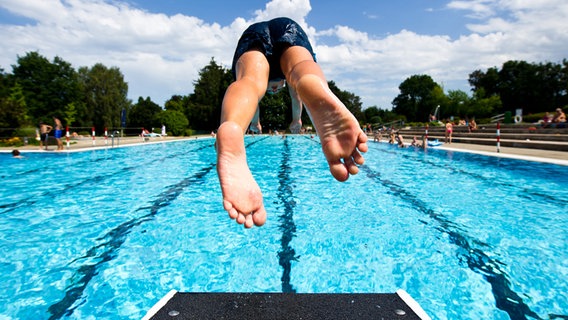 Ein Junge springt in einem Freibad ins Wasser © picture alliance / dpa Foto: Daniel Bockwoldt
