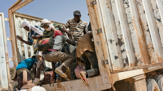 Flüchtlinge in Nordafrika klettern auf die Ladefläche eines Lastwagen. © picture alliance Foto: Jerome Delay