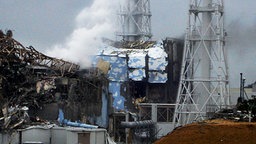 Die beschädigten Reaktorgebäude 3 (l.) und 4 des AKW Fukushima I am 15. März 2011. © dpa 