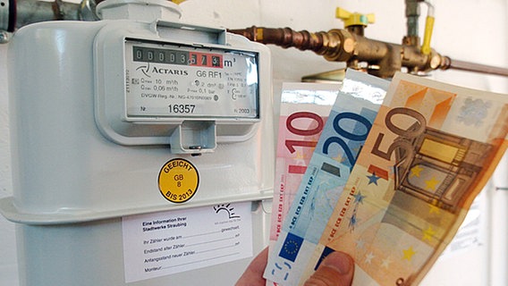 Geldscheine vor einem Gaszähler © dpa Foto: Armin Weigel