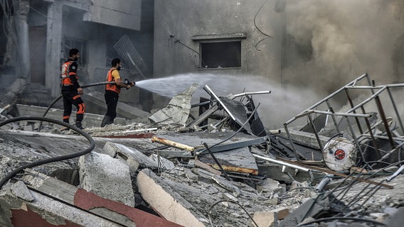Palästinensische Rettungskräfte inspizieren die Trümmer nach einem israelischen Angriff im Gazastreifen. © dpa-Bildfunk Foto: Mohammad Abu Elsebah
