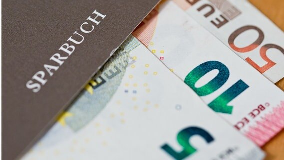 Ein Sparbuch, ein 5, ein 10, 50 Euroschein. © Picture Alliance Foto: Daniel Karmann