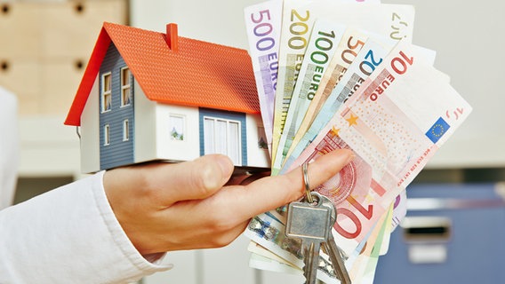 A miniature house and money are at your fingertips.  © Fotolia.com Photo: Robert Kneschke