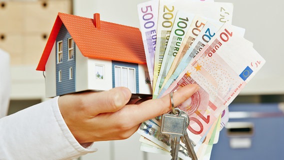 Ein Miniaturhaus und Geld liegen auf einer Hand. © Fotolia.com Foto: Robert Kneschke