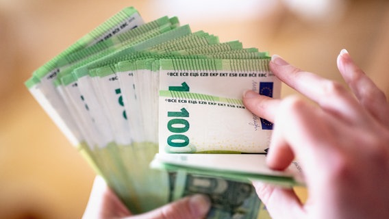 Eine Frau hält ein Bündel 100-Euro-Scheine in der Hand. © Matthias Balk 