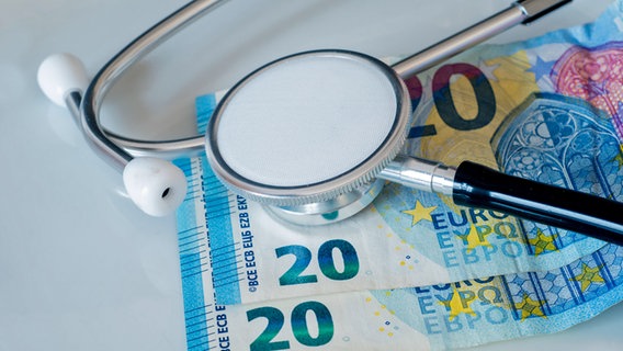 Nahaufnahme eines Stethoskops und von Geldscheinen, Symbolfoto für Kosten medizinischer Behandlungen © picture alliance / CHROMORANGE Foto: Andreas Poertner