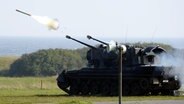 Ein Flugabwehrkanonenpanzer "Gepard" (kurz Flak-Panzer) der Bundeswehr schießt während einer Vorführung. © picture alliance Foto: Carsten Rehder