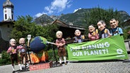 Demonstranten von Oxfam tragen auf einem Platz in Garmisch-Partenkirchen Politiker-Köpfe. © dpa-Bildfunk Foto: Angelika Warmuth
