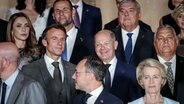 Spanien, Granada: Bundeskanzler Olaf Scholz (mittlere Reihe, 2.v.r, SPD) und Frankreichs Präsident Emmanuel Macron (l) stehen beim Gipfeltreffen der Europäischen Politischen Gemeinschaft mit weiteren Staats- und Regierungschefs für ein Foto zusammen. © dpa Foto: Kay Nietfeld