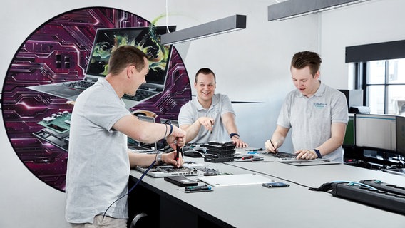 Drei Mitarbeiter des Unternehmens Glad Teknik arbeiten an der Reparatur von Computern. © Glad Teknik Foto: Glad Teknik