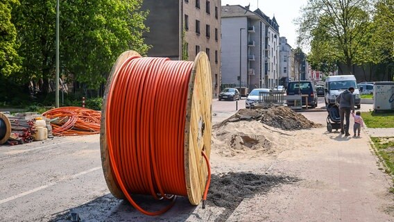 Kabeltrommel mit Glasfaserkabel auf einem Gehweg in einem Wohnviertel. © picture alliance Foto: Rupert Oberhäuser